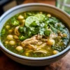Grünes Hühnchen Pozole Verde Rezept Zutaten: - 1 kg Hühnchenbrust - 2 Liter Hühnerbrühe - 5 Tomatillos - 1 grüne Paprika - 2 Jalapeños - 1 Zwiebel - 2 Knoblauchzehen - 1 Teelöffel Kreuzkümmel - 1 Teelöffel Salz - 1 Teelöffel Pfeffer - 400 g Mais - Frischer Koriander - Limetten Anleitung: 1. Hühnchen kochen, bis es durch ist. 2. Tomatillos, Paprika, Jalapeños, Zwiebel und Knoblauch in einem Mixer pürieren. 3. Hühnchen in kleine Stücke schneiden. 4. Hühnerbrühe in einen großen Topf geben, das pürierte Gemüse hinzufügen, Kreuzkümmel, Salz und Pfeffer dazugeben und zum Kochen bringen. 5. Mais und Hühnchen hinzufügen und 10 Minuten köcheln lassen. 6. Mit frischem Koriander und Limettensaft servieren.