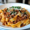 Rinderbolognese Rezept Zutaten: 400 g Rinderhackfleisch 1 Zwiebel 2 Knoblauchzehen 1 Karotte 1 Sellerie 400 g Tomaten (gehackt) 2 EL Tomatenmark 1 TL Oregano 1 TL Basilikum Salz Pfeffer Olivenöl 300 g Spaghetti Parmesan Anleitung: 1. Zwiebel, Knoblauch, Karotte und Sellerie fein hacken. 2. In einer Pfanne Olivenöl erhitzen und das Gemüse andünsten. 3. Rinderhackfleisch hinzufügen und anbraten, bis es braun ist. 4. Tomaten, Tomatenmark und Gewürze hinzufügen. 5. Bei niedriger Hitze 30 Minuten köcheln lassen. 6. In der Zwischenzeit Spaghetti nach Packungsanweisung kochen. 7. Spaghetti abgießen und mit der Bolognese servieren. 8. Mit Parmesan bestreuen.